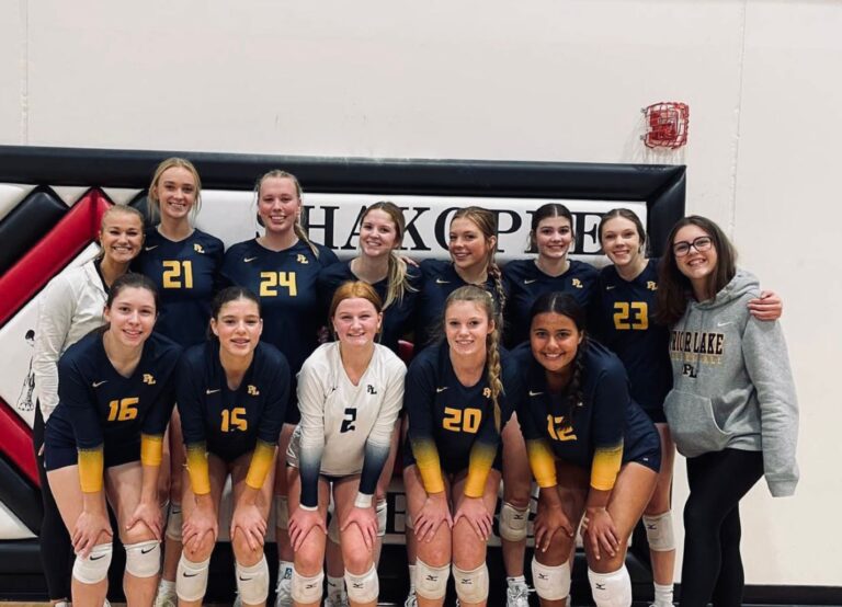 Squadra femminile di pallavolo di una high school americana in posa nella palestra.