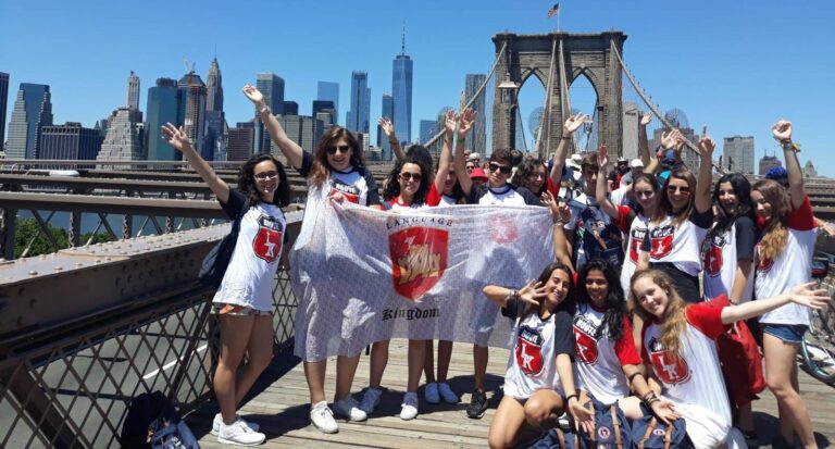 Gruppo di studenti italiani festeggia sul Ponte di Brooklyn con lo striscione di Language Kingdom.