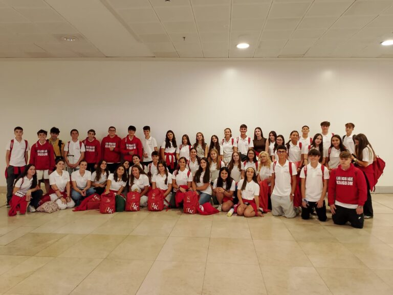 Gruppo numeroso di studenti in posa in una grande sala.
