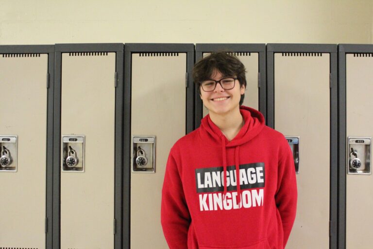 Studente con la felpa di Language Kingdom davanti agli armadietti della scuola canadese.