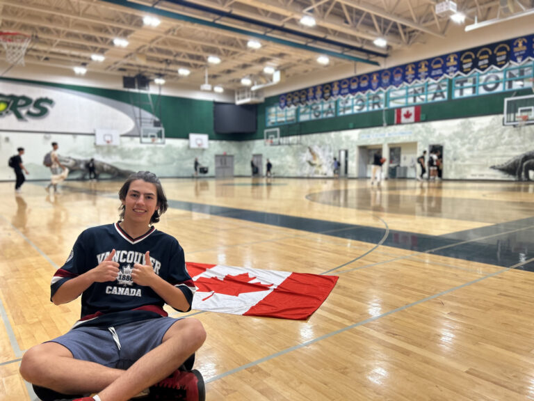 Studente seduto con la bandiera del Canada nella palestra della scuola.