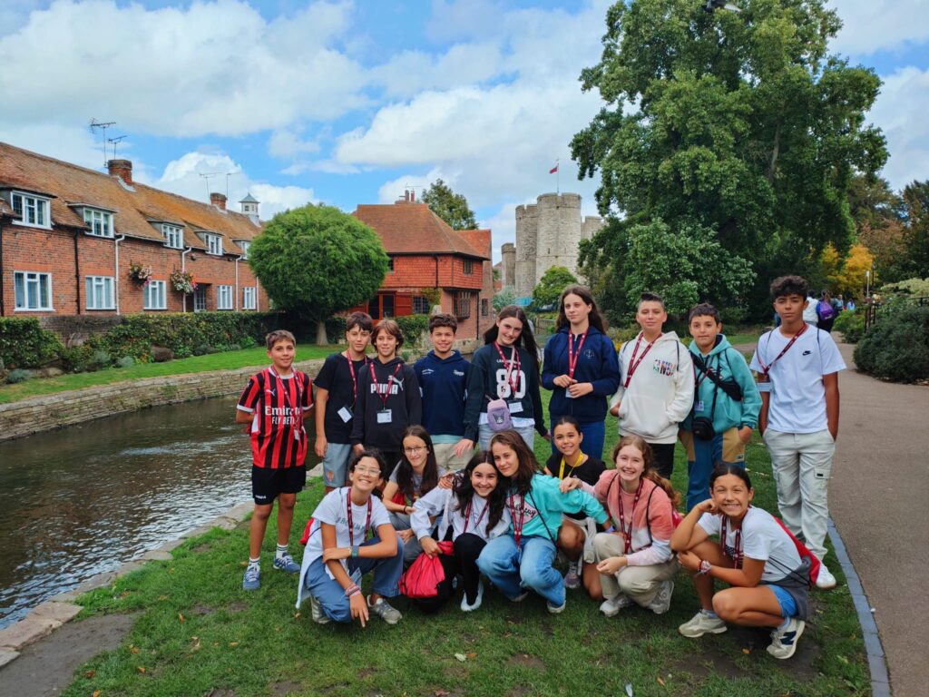 Gruppo di studenti in un parco di Canterbury, accanto alle mura della città.