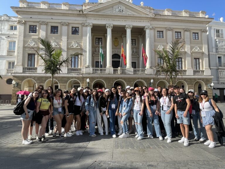 Gruppo numeroso di studenti davanti a un palazzo neoclassico, in Spagna.