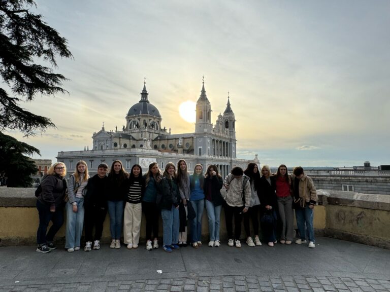 Gruppo di studenti davanti alla cattedrale dell'Almudena di Madrid, al tramonto.