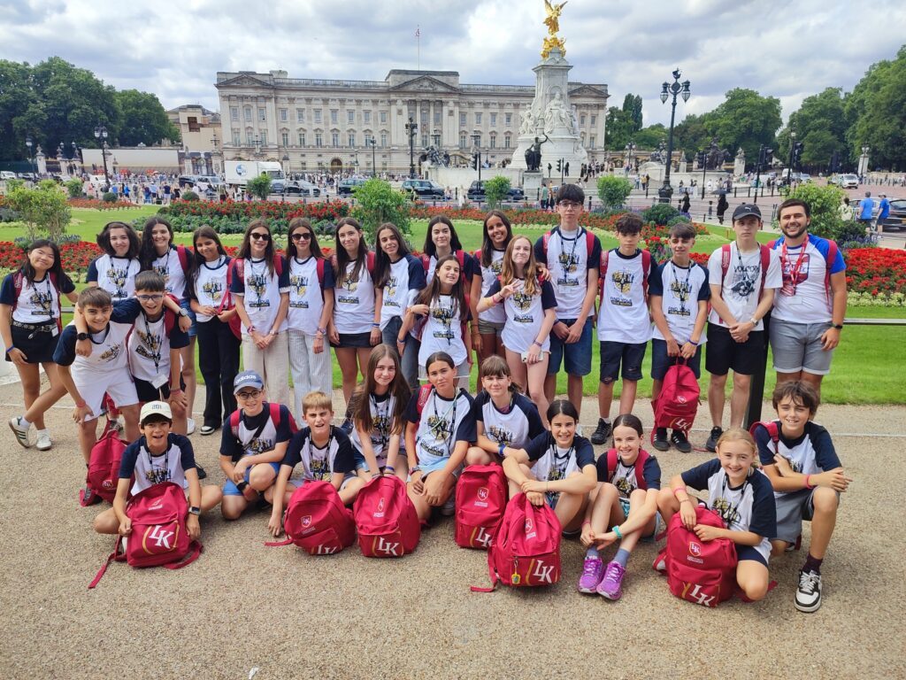 Gruppo di studenti con le borse rosse LK davanti a Buckingham Palace.