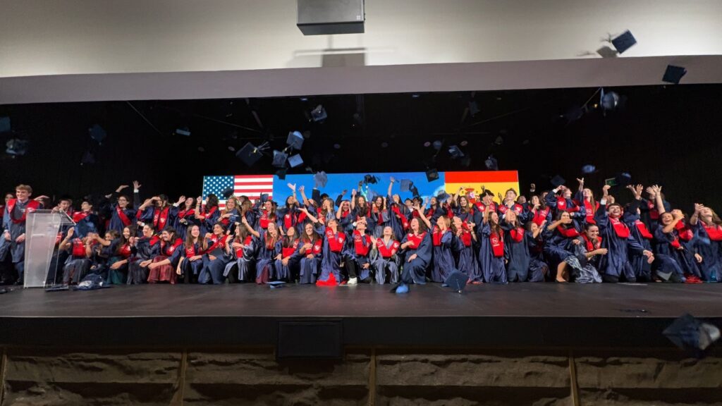 Studenti diplomati lanciano in aria il tocco sul palco della cerimonia di graduation.